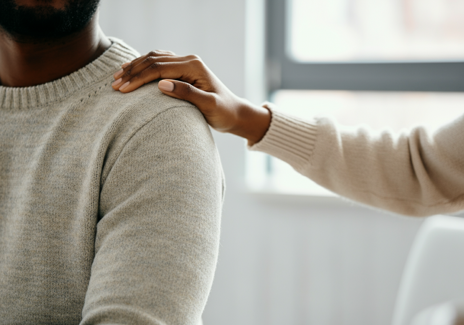 A person offering a comforting hand to a friend who appears distressed, symbolizing initial support for mental health struggles.