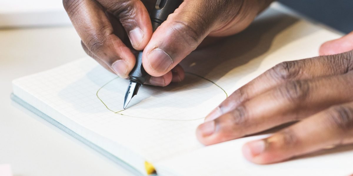 A person writing notes, symbolizing the therapeutic process of self-reflection and rebuilding one's value system.