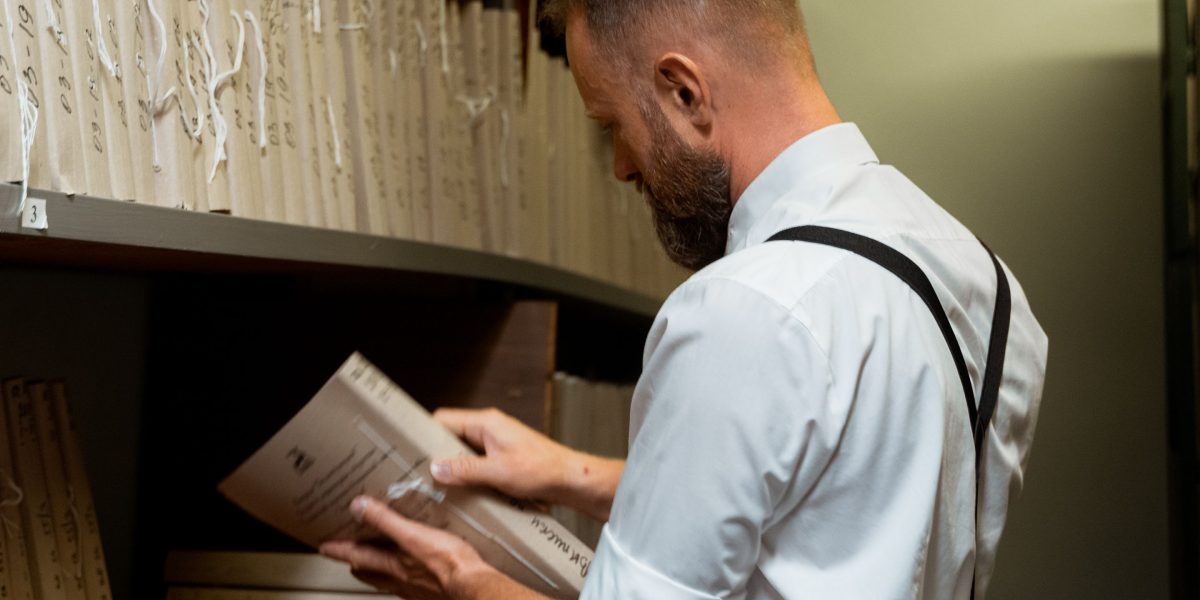 A person diligently reviewing documents or research papers to find accurate and trustworthy data.