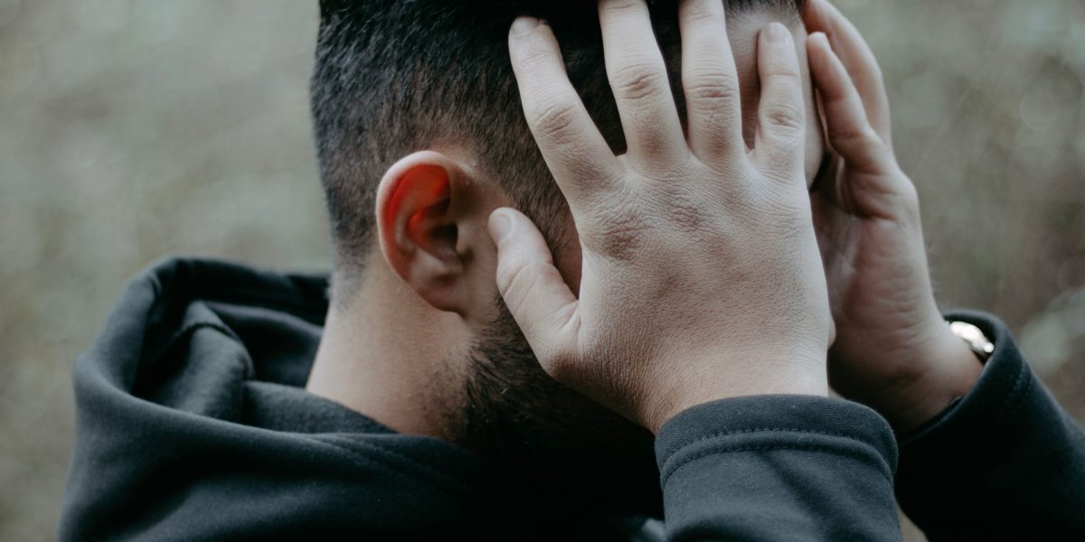 A person feeling contemplative, reflecting the experience of isolation and uncertainty common with mental health conditions.