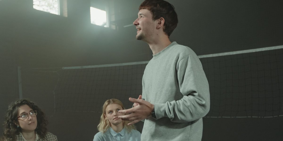 A person confidently speaking in a group setting, representing the act of breaking stigma by sharing experiences.