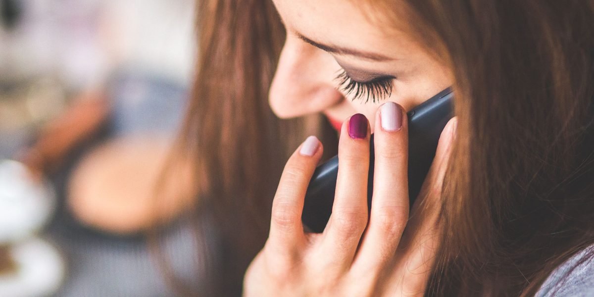 An individual actively making a phone call, taking the crucial first step toward accessing support.