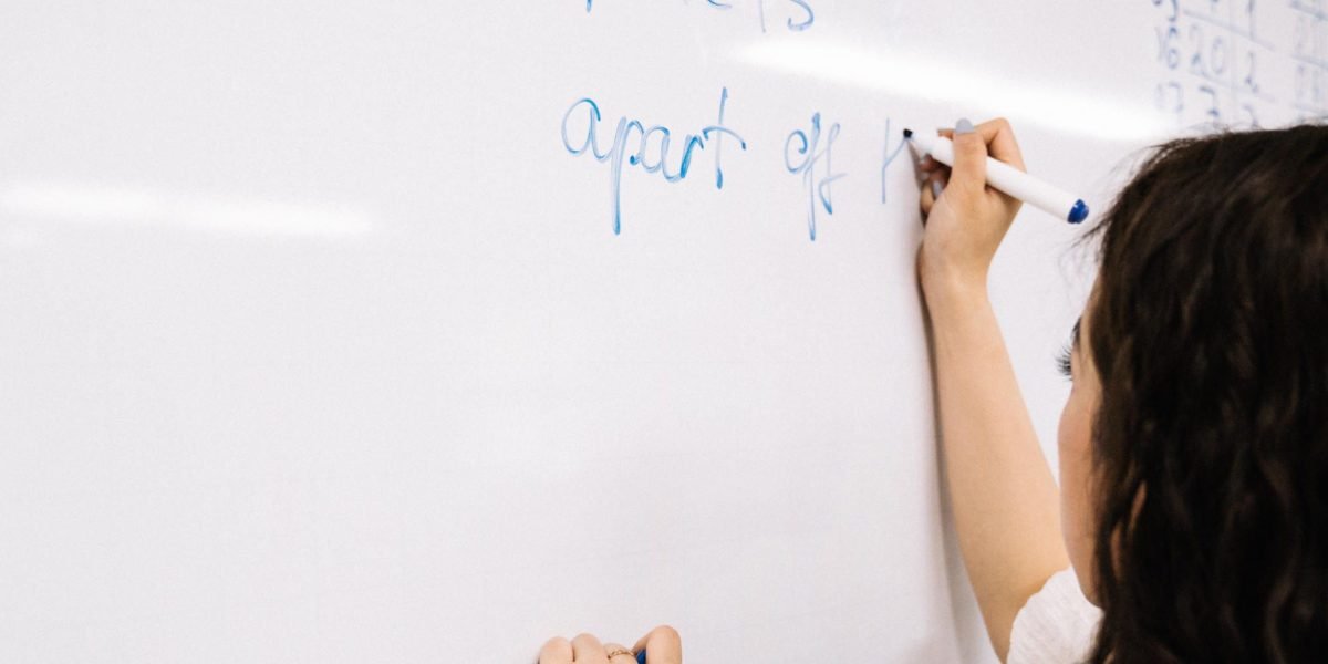 An individual actively outlining a plan on a whiteboard, reflecting the process of creating a sustainable mental health action plan.
