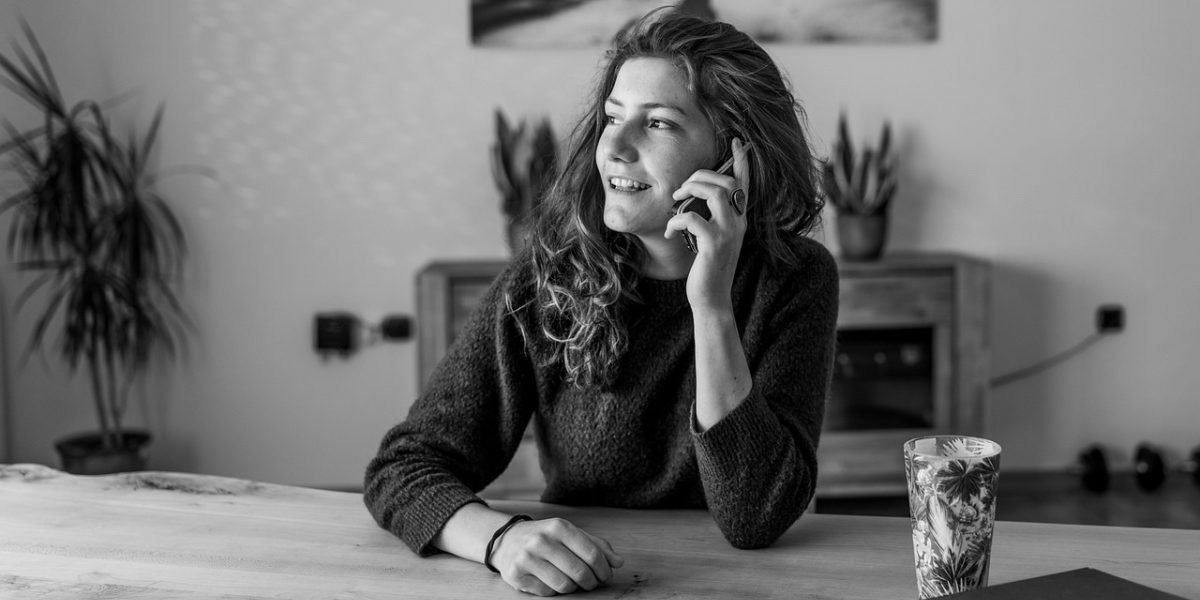 A person makes a phone call, depicting the initial step of reaching out for mental health assistance.